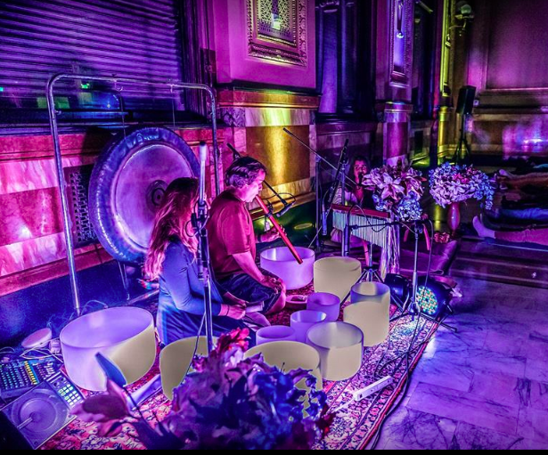 Musicians layering crystal bowls and gong